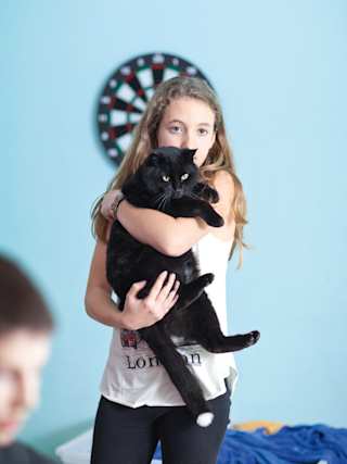 Mädchen hält eine Katze in den Armen