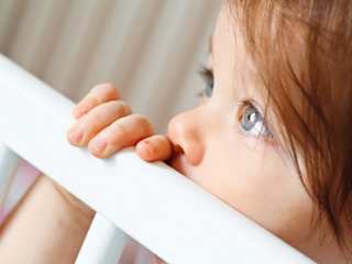 Kind im Babybett