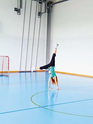 Sylvie macht ein Rad in der Turnhalle