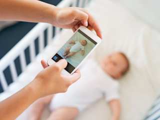Frau fotografiert Baby für Social-Media-Post.