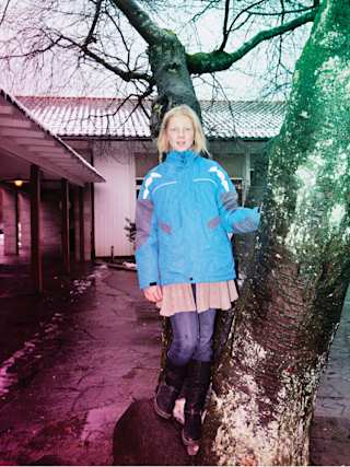 Hanna kletter einen Baum hoch vor ihrer Schule