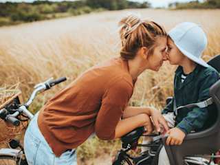 Mutter mit Kind innig in der Natur am Feld