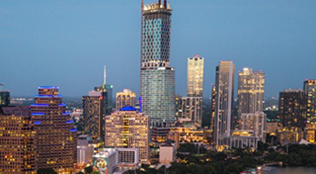 The Austin, Texas skyline at dusk, featuring the iconic Jenga-like Independent tower and the Frost Bank Tower in a vibrant urban landscape.
