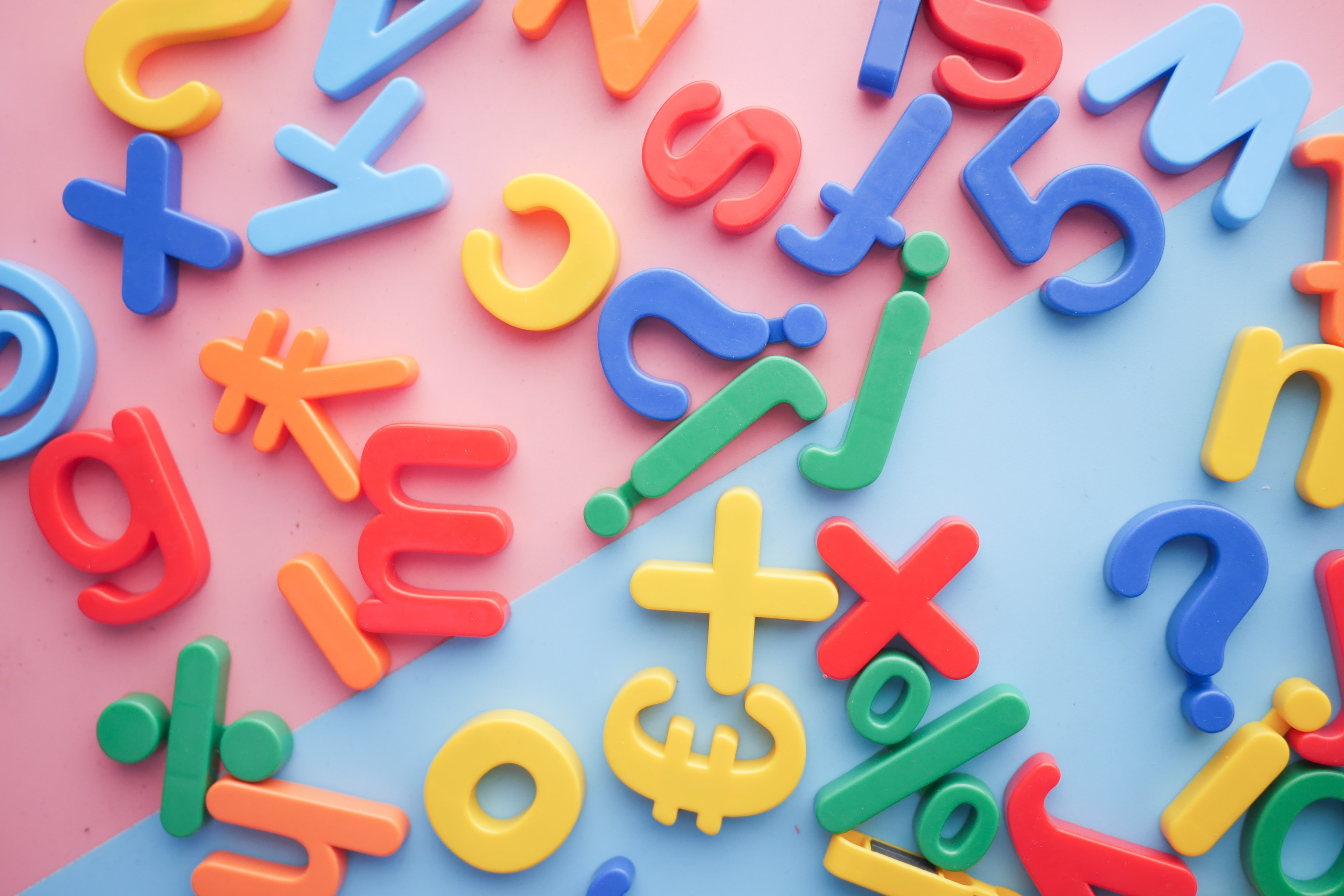 Colorful alphabets, numbers and other symbols on a pink and blue background