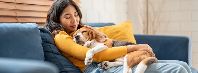 Dog Anxiety: Symptoms, Treatments, and How to Help A photo of a woman holding her dog tightly for article on separation anxiety in dogs