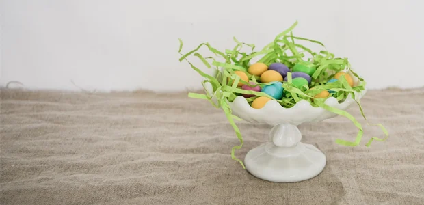 synthetic Easter grass with colourful eggs inside a white bowl synthetic Easter grass with colourful eggs inside a white bowl