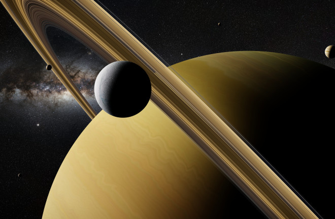 Saturn moon Enceladus in front of planet Saturn, rings and other moons