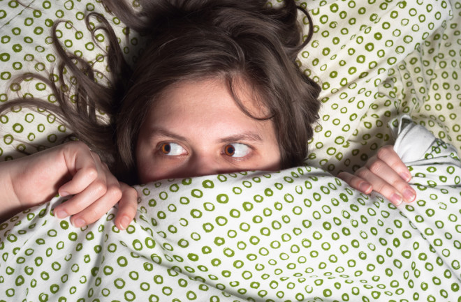 Woman lying in bed wide awake with a sleep problem