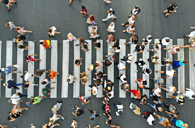 pedestrians cross a busy street at crosswalk - shutterstock 1486465109