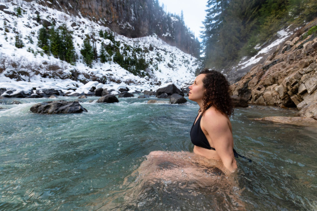 cold water plunge woman in a mountain lake with snow