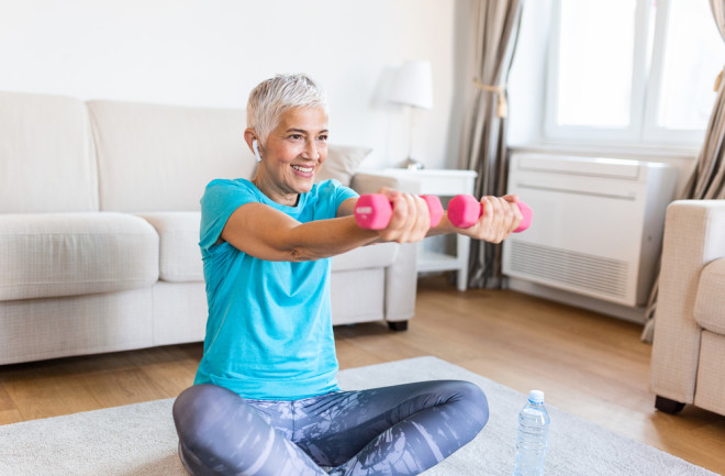 Senior woman exercising in living room 