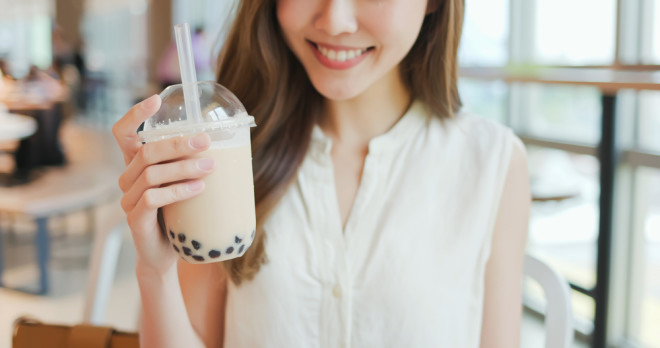 close up of a young woman holding a bubble tea at a restaurant 
