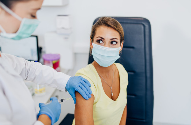 covid-19 vaccine woman getting a shot mask doctor healthcare public health - shutterstock