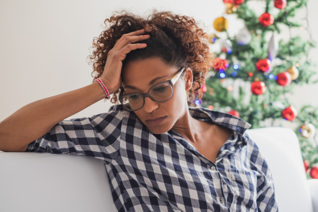 woman-with-headache-by-christmas-tree