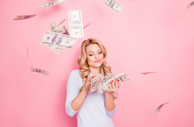 blonde-woman-making-it-rain-with-cash-pink-background