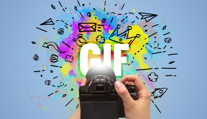 Close-up of a hand holding digital camera with abstract drawing and GIF inscription