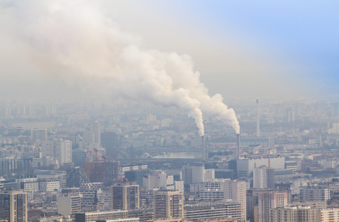 Air pollution by smoke coming out of two factory chimneys,