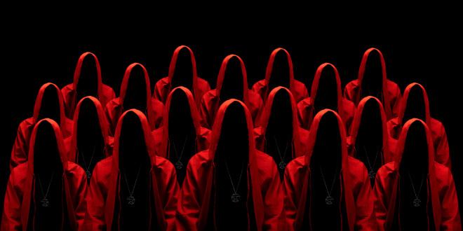 Group of mysterious people in red hooded cloaks representing a cult