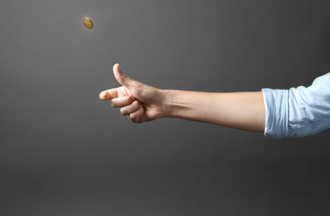 Person flipping a coin