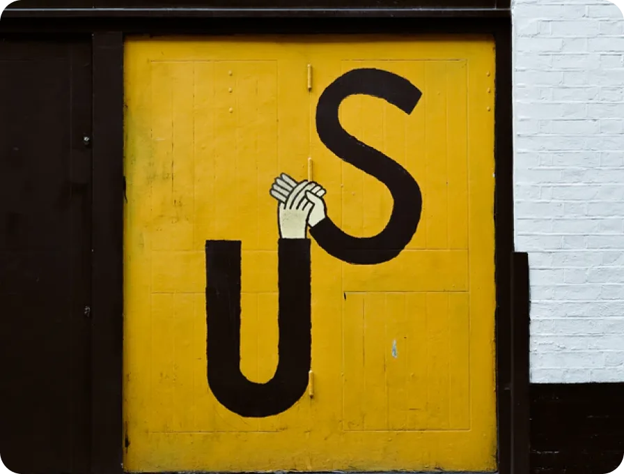 Building wall with words "us" and the letter holding hands.