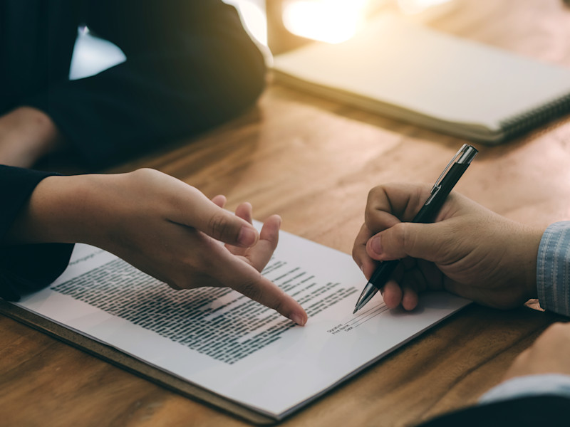 man signing real estate contract with a pen