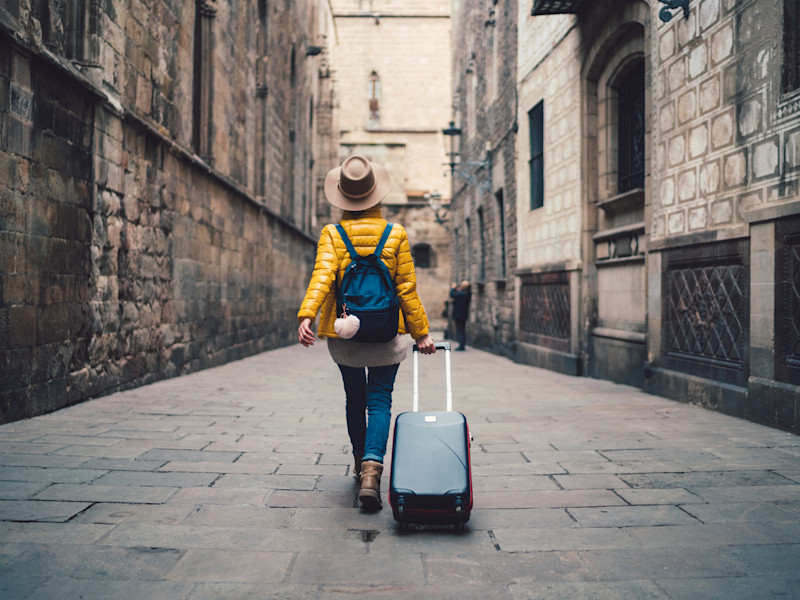 Young woman with suitcase enjoying her career break
