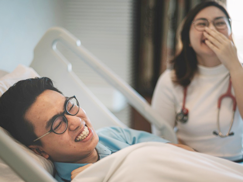 Female NP and male patient laughing about something funny