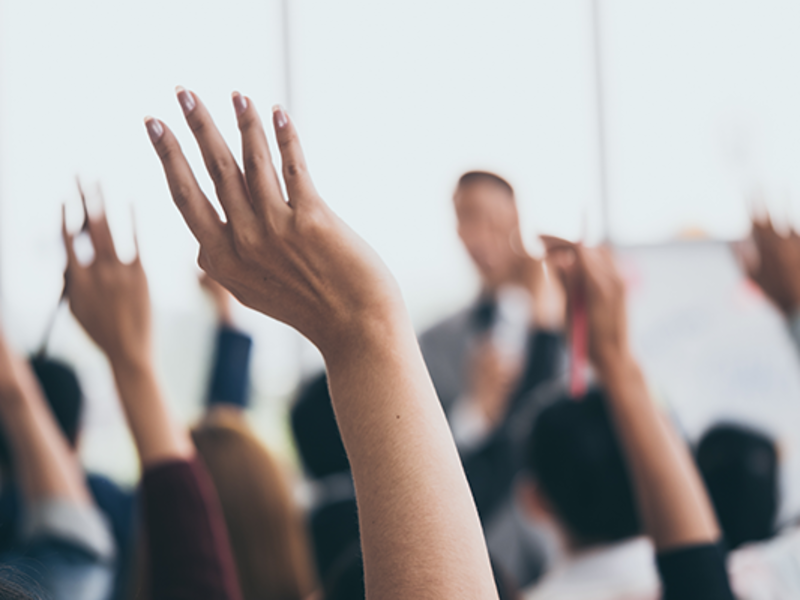Audience raising hands during seminar