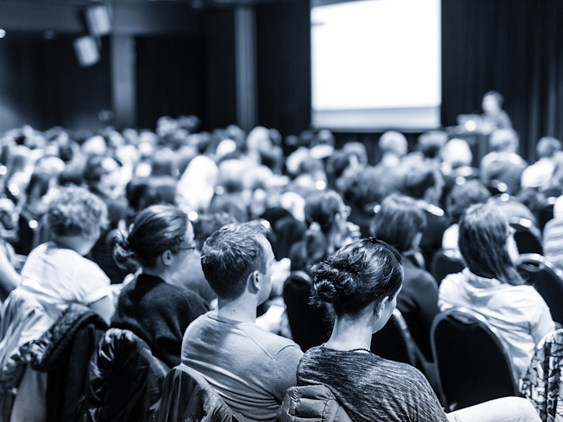 Black and white photo of people sitting in an auditorium.
