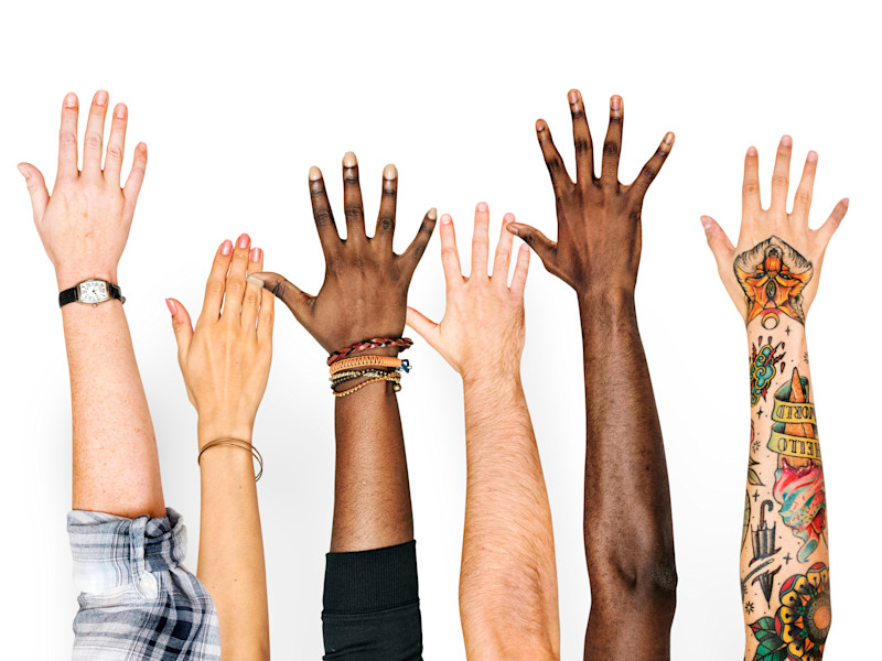 People of different ethnicities raising their arms