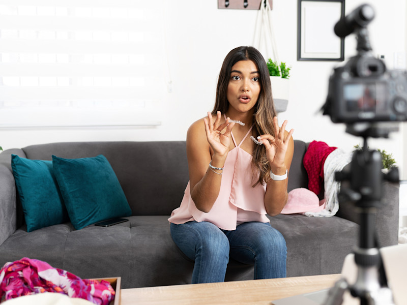 Dental or hygienist influencer sharing her experience with an invisible orthodontics dental treatment while talking to a camera