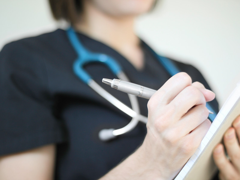 Nurse writing medication out for a patient.