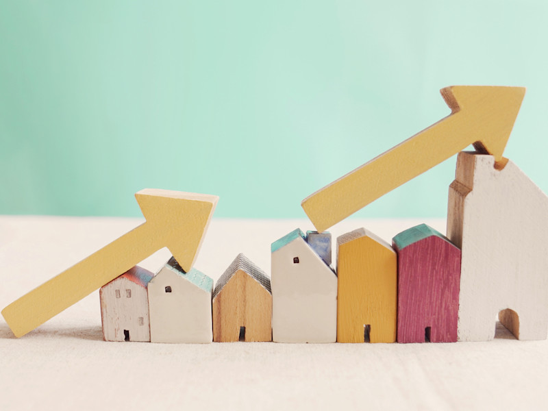Row of wooden houses arranged from shortest to tallest with yellow arrows resting on top of them highlighting the progression of height.
