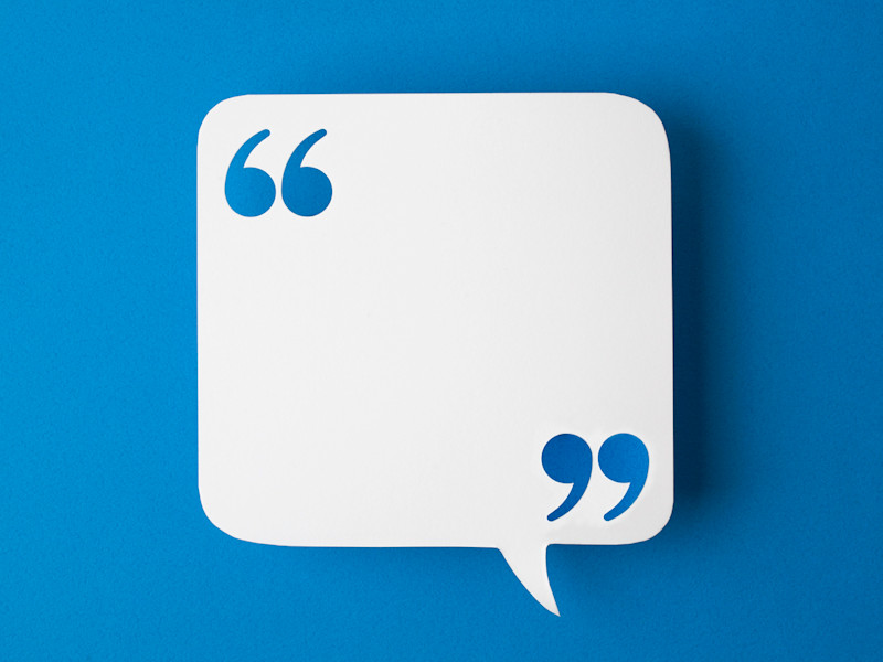 White square speech bubble with quotation marks in opposite corners against royal blue background.