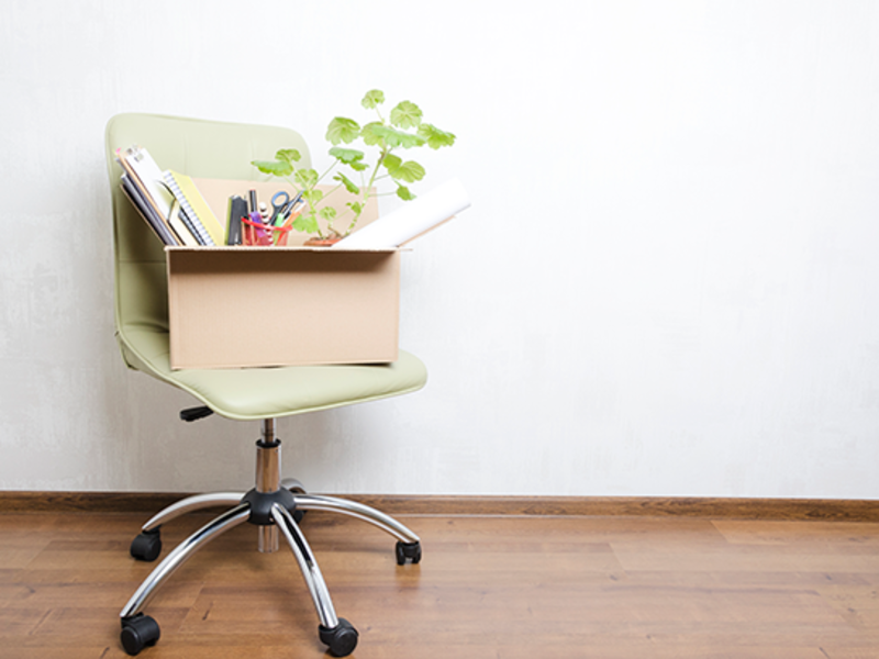 Box of things from a person's work desk on a rolling chair