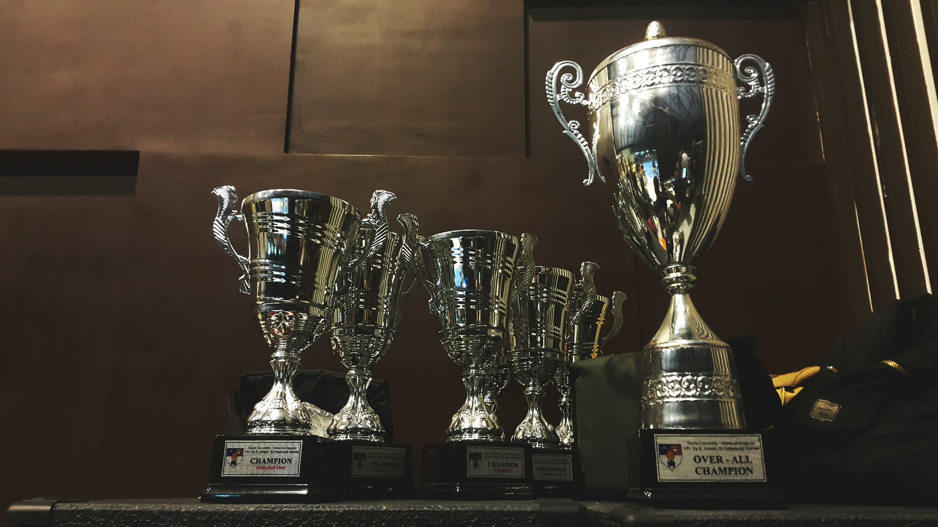 Multiple silver trophies on a shelf