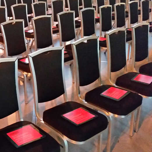 Custom Event App running on iPads neatly placed on chairs in auditorium