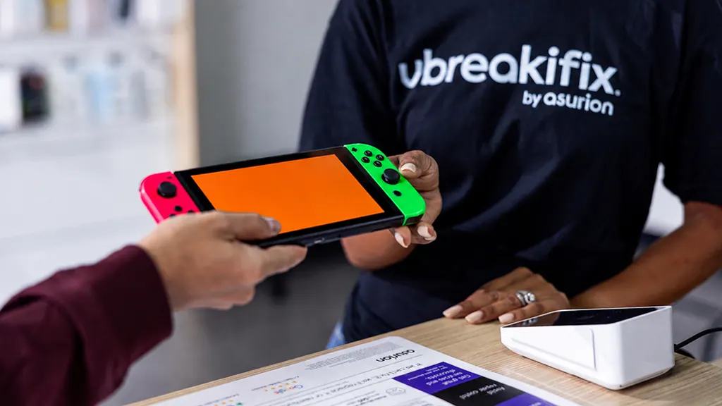 Customer handing their Nintendo Switch with an orange screen over to uBreakiFix expert for repair