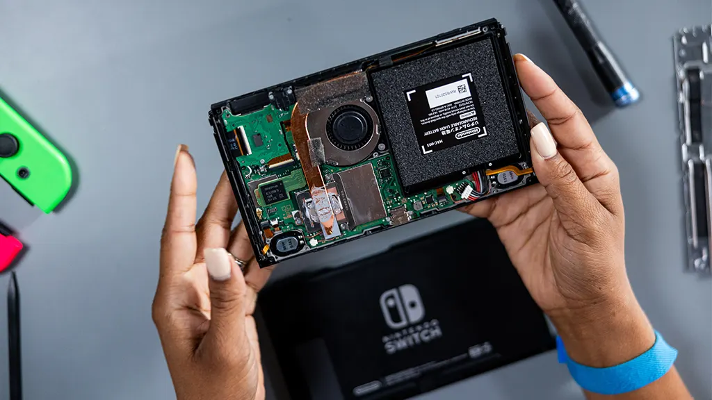 uBreakiFix repair expert opening a Nintendo Switch to troubleshoot overheating