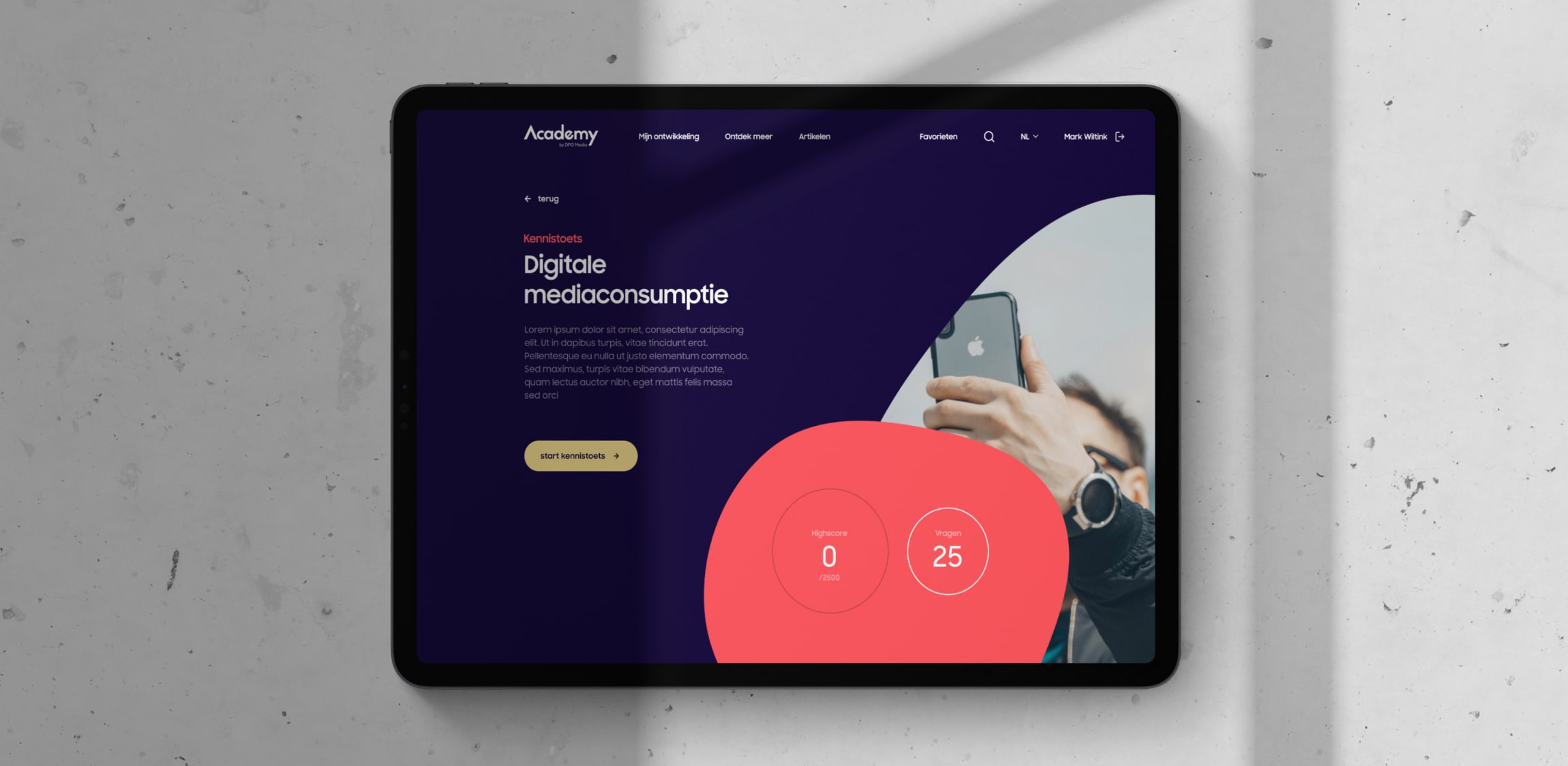 De homepagina van DPG Academy getoond op een tablet die ligt op een witte marmeren ondergrond