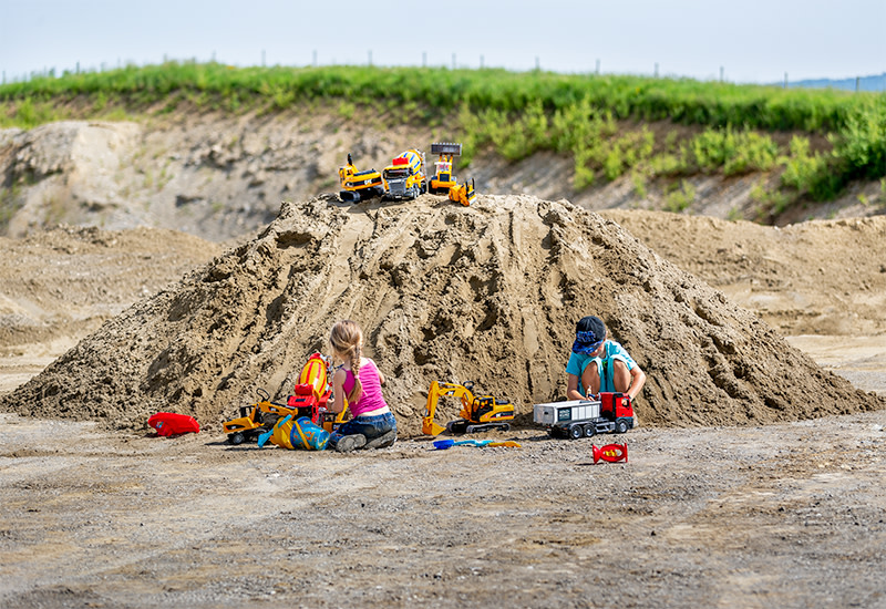 Kinder spielen in der Kiesgrube mit Schlemmsand