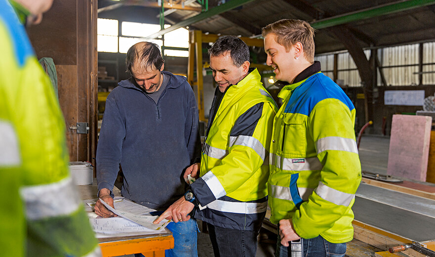 Projektbesprechung in der Kleinelementfertigung Drei Mitarbeiter während einer Besprechung.