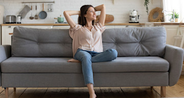 Mujer joven feliz descansando en su sofá
