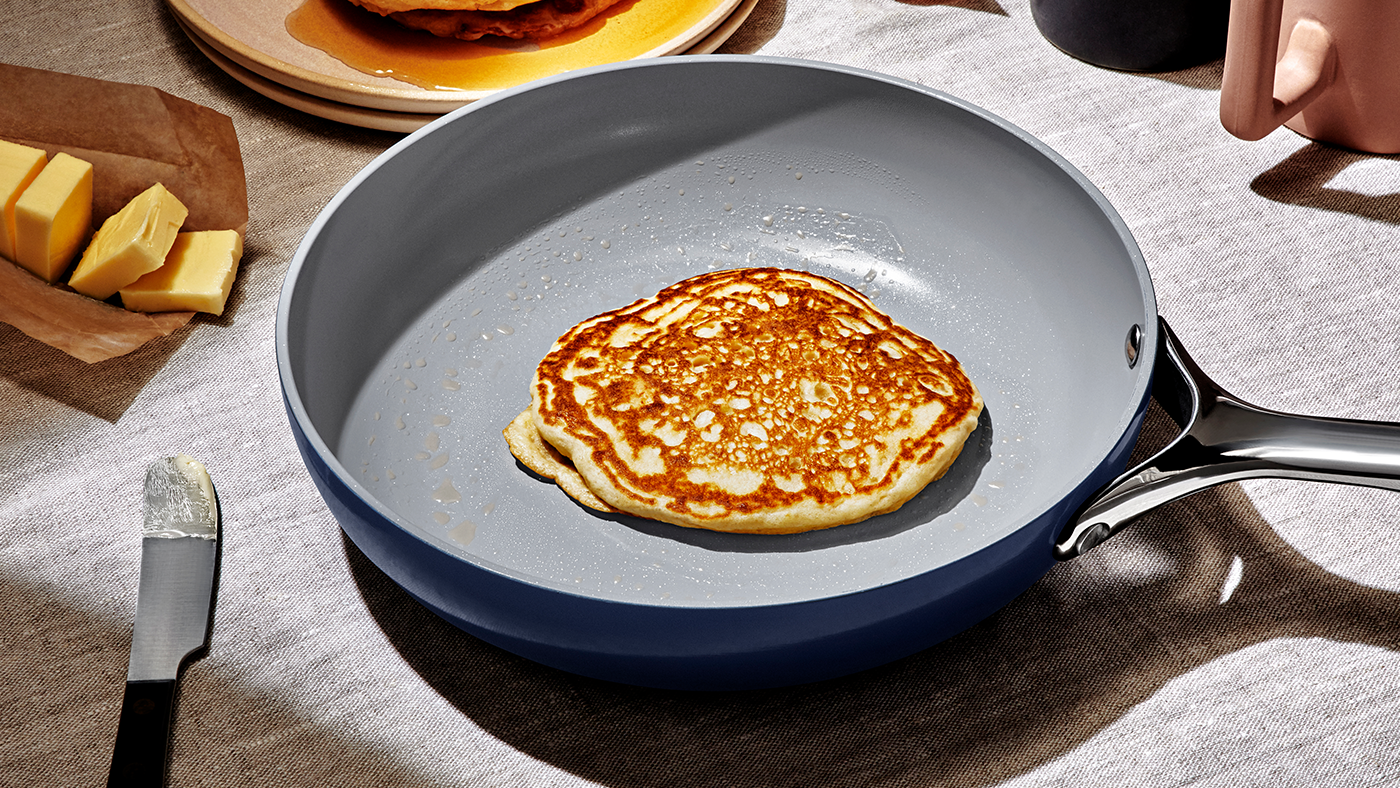 A non-stick fry pan with a pancake on a table