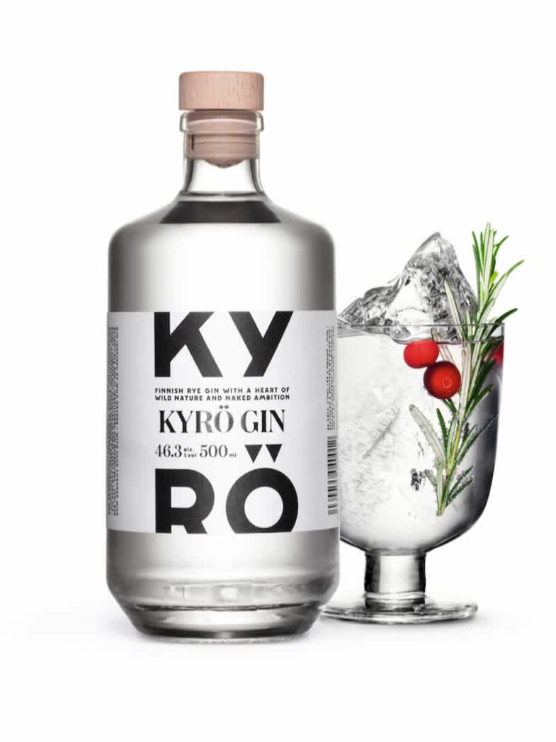 A 500ml bottle of Kyrö Gin, next to it an Iittala cocktail glass filled with Kyrö Gin, a shard of hand-cut ice, cranberries, rosemary, and Fever-Tree Indian tonic water. 