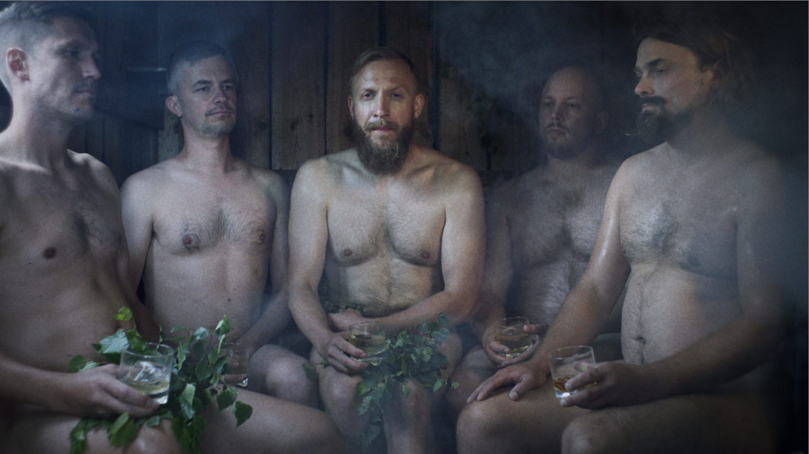 Five men sit in a finnish sauna naked.