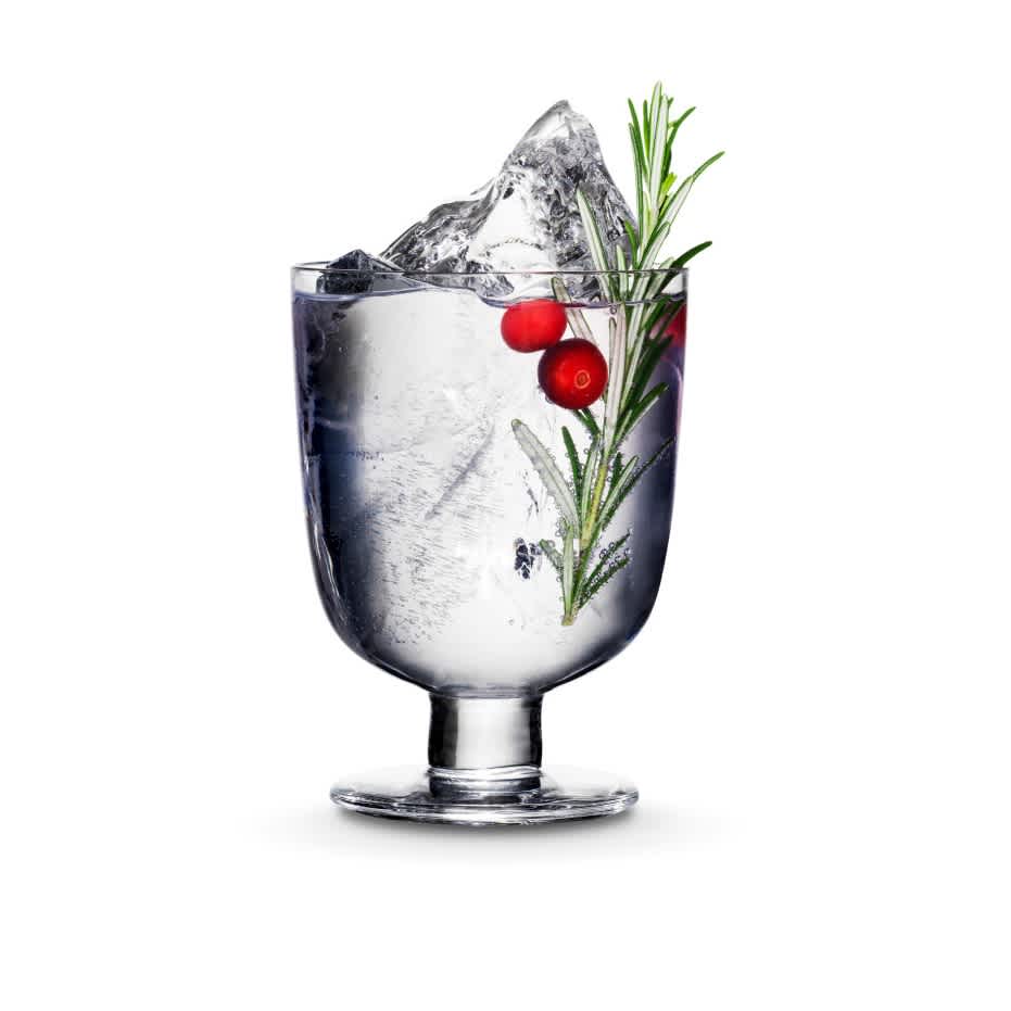 Kyrö Gin served in an Iittala cocktail glass with a shard of hand-cut ice, cranberries, rosemary, and Fever-Tree Indian tonic water. 
