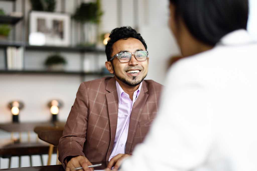 A man in a suit smiles during a business meeting.