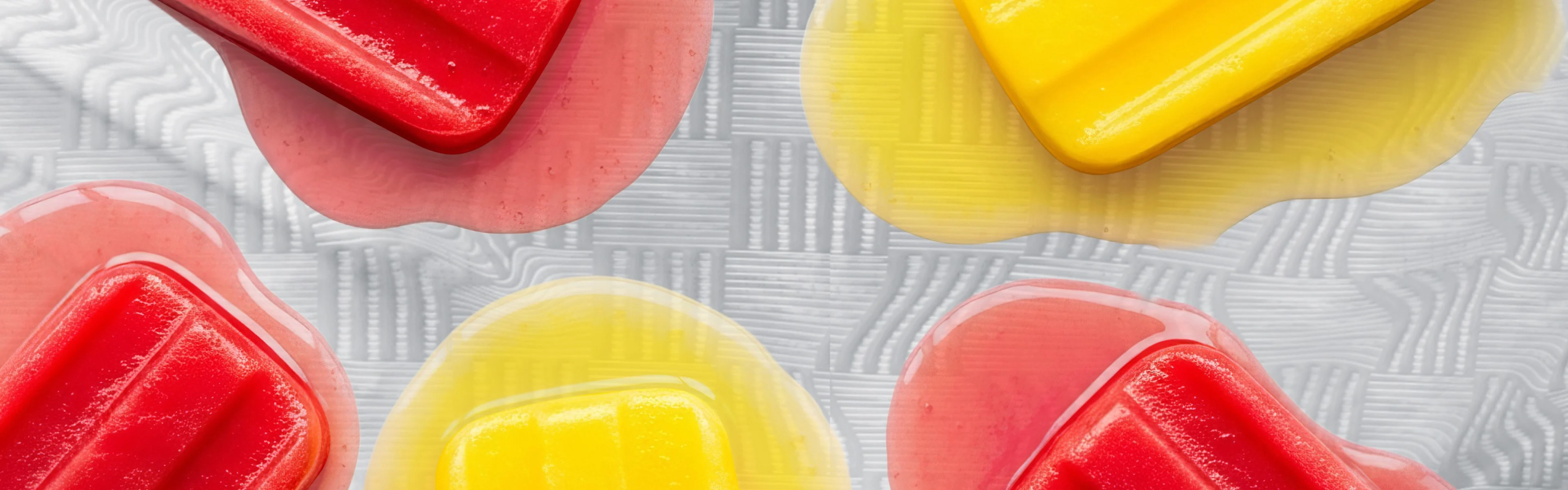 Red and Yellow popsicles melting on a white cloth
