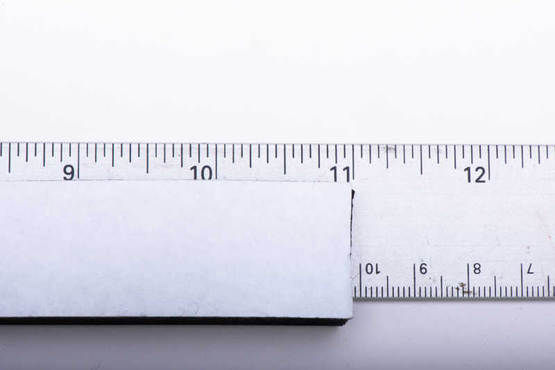 A ruler measuring a foam strip at the 11